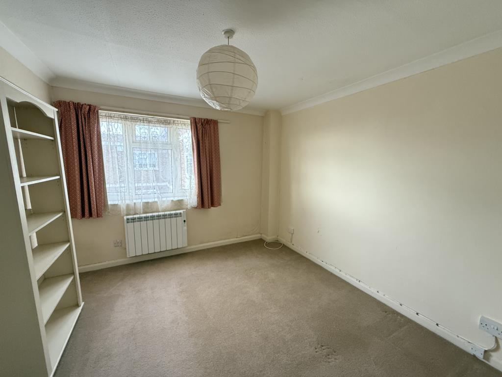 Lot: 126 - TWO-BEDROOM TOP FLOOR FLAT WITH UNINTERRUPTED SEA VIEWS - Bedroom one with fitted carpet and painted walls